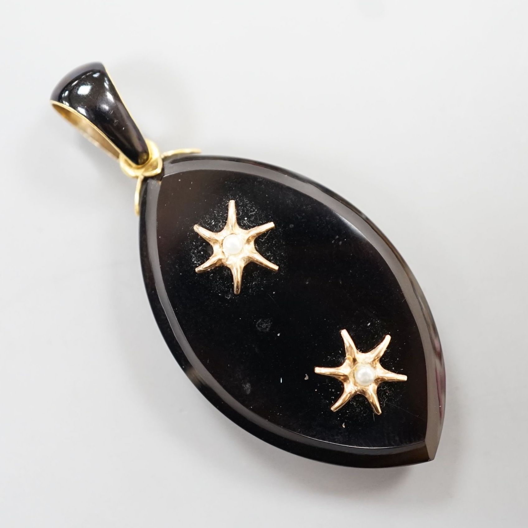 A Victorian yellow metal, black enamel, black onyx and seed pearl set mourning pendant, 57mm (one pearl set motif loose)